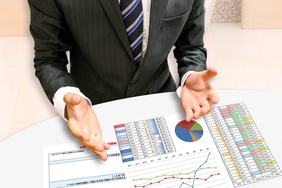 資料グラフ上で説明するビジネスマン